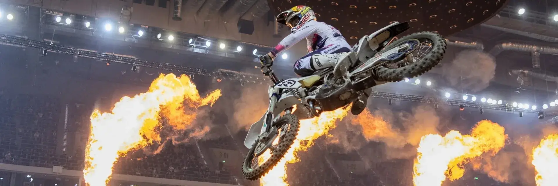Pilote Super Enduro en plein saut entre les flammes de l'Arena